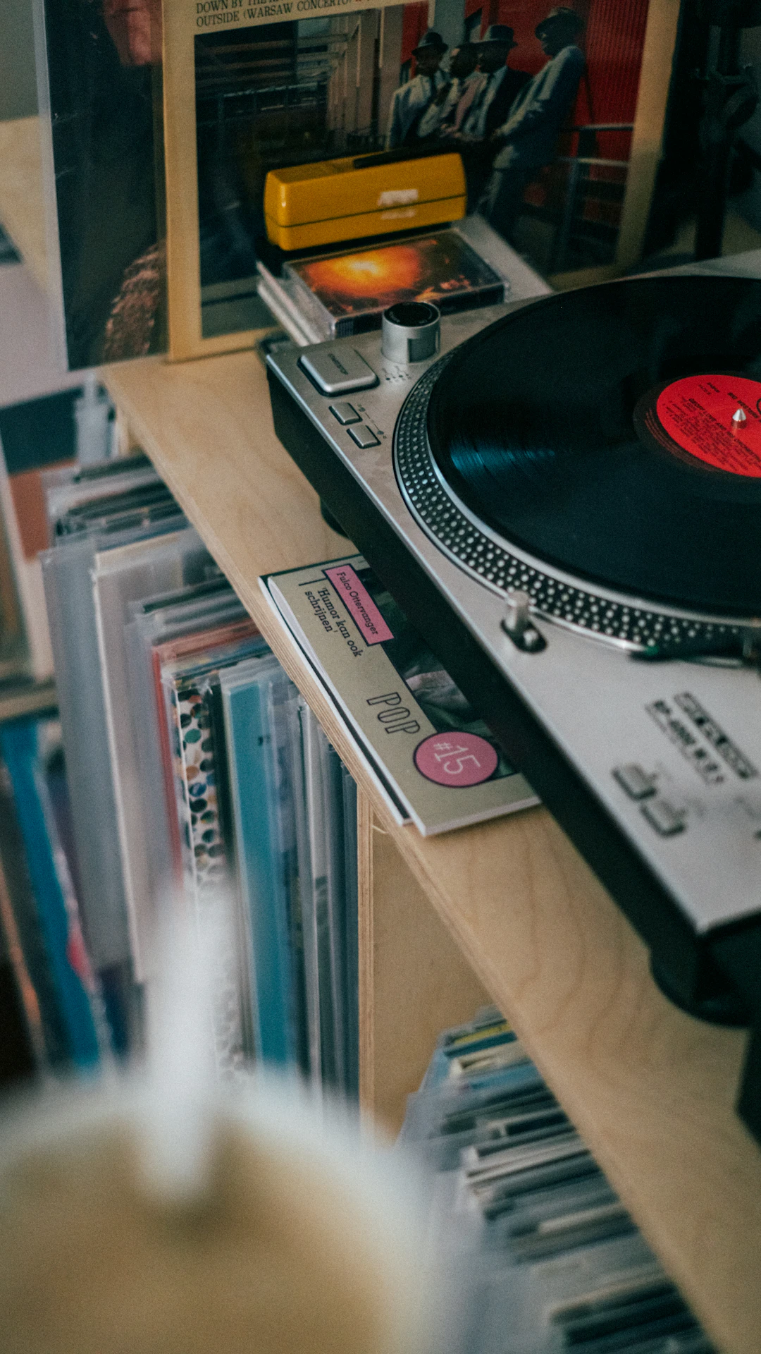 a record player sitting on top of a wooden shelf