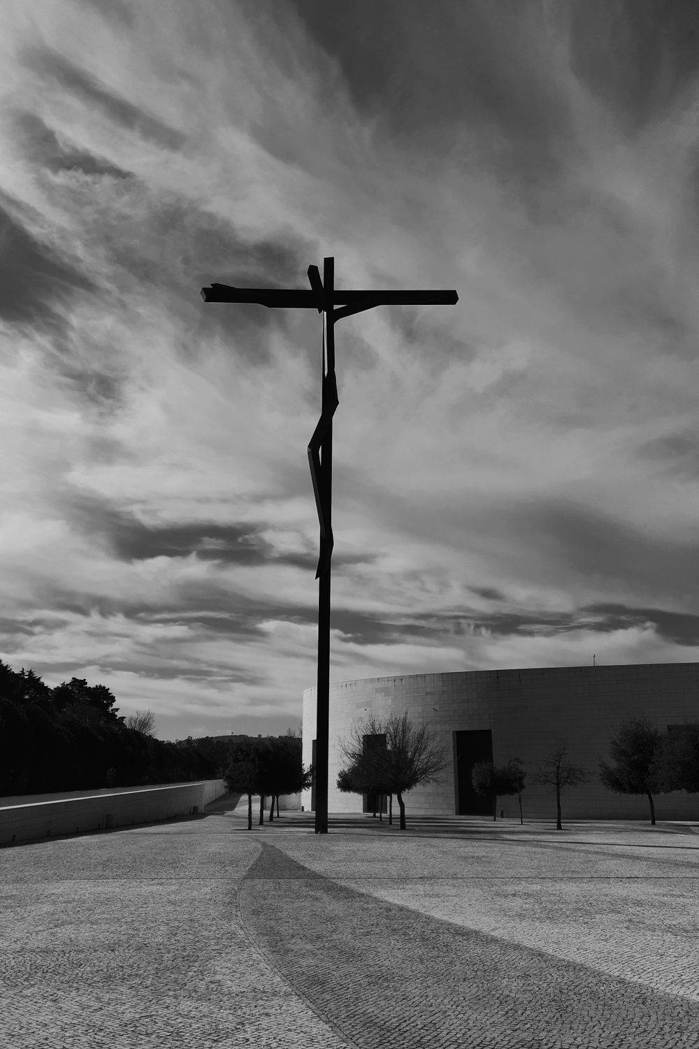 Dramatic black and white photo of a crucifix at the Sanctuary of Fátima, Portugal.