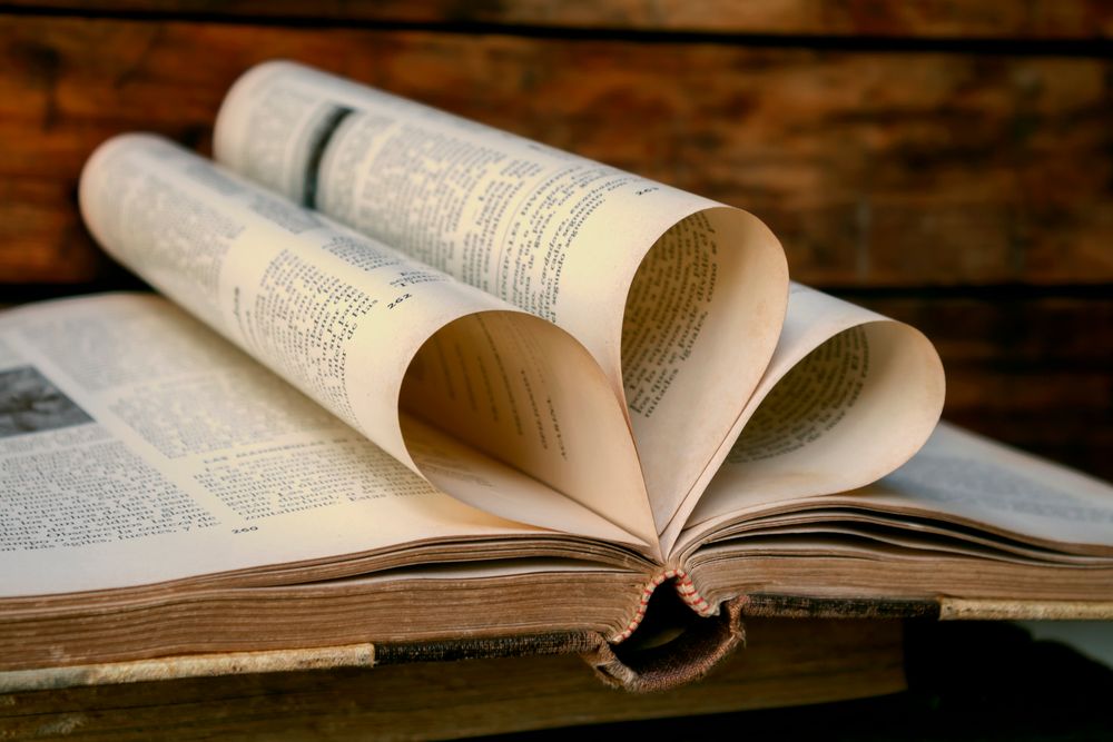 A vintage book with heart-shaped pages against a wooden background, symbolizing love for reading.