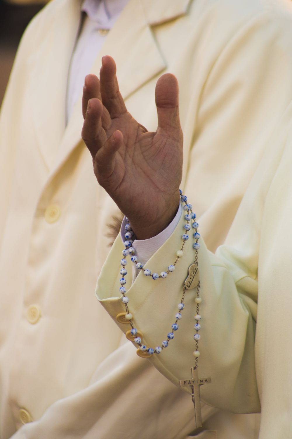 A hand wearing a rosary beads bracelet, symbolizing Christian faith, captured in a peaceful moment.