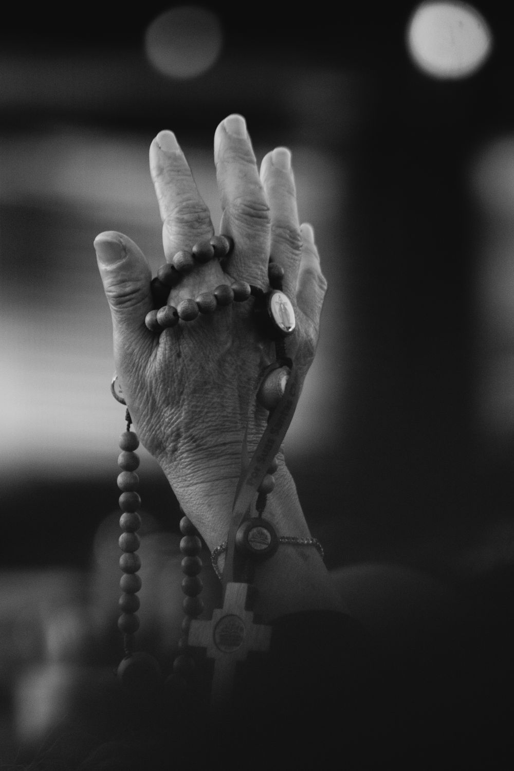 A close-up of hands holding a rosary, symbolizing faith and prayer.