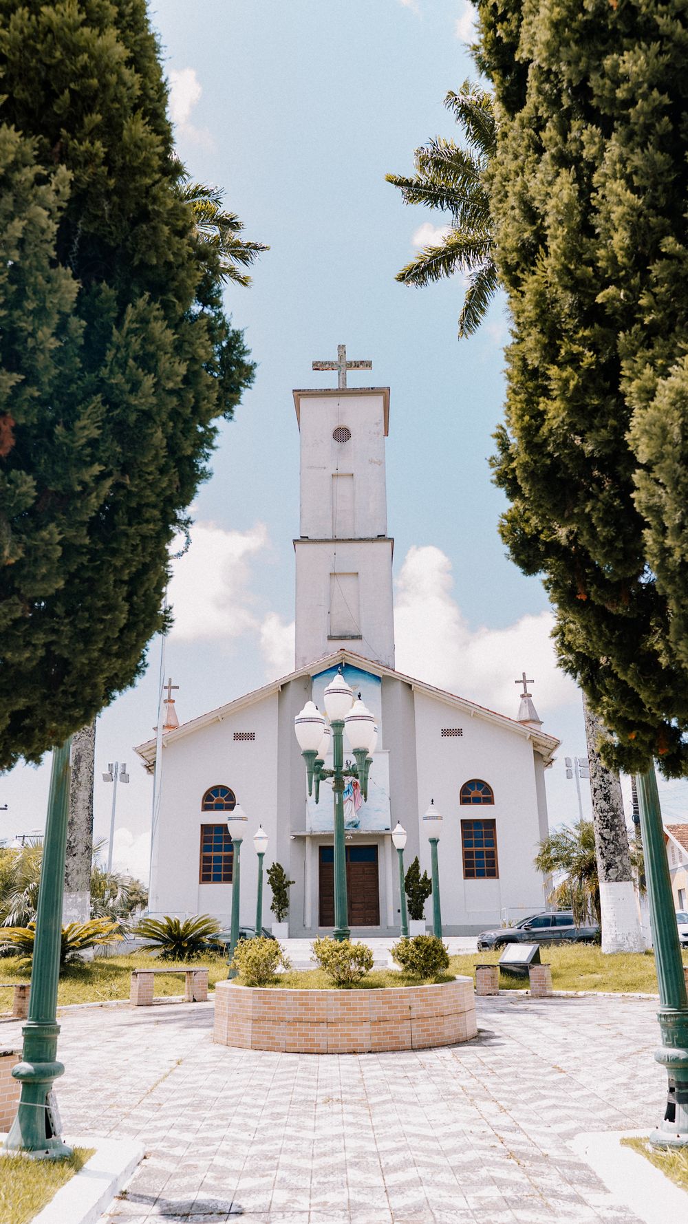 A picturesque church in Penha, Santa Catarina with green trees framing the view.