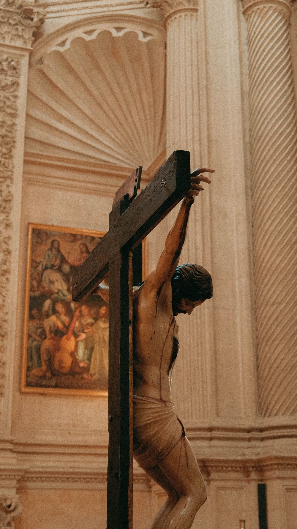 Historic statue of Jesus on the cross inside a cathedral in Seville, Spain, showcasing religious art.