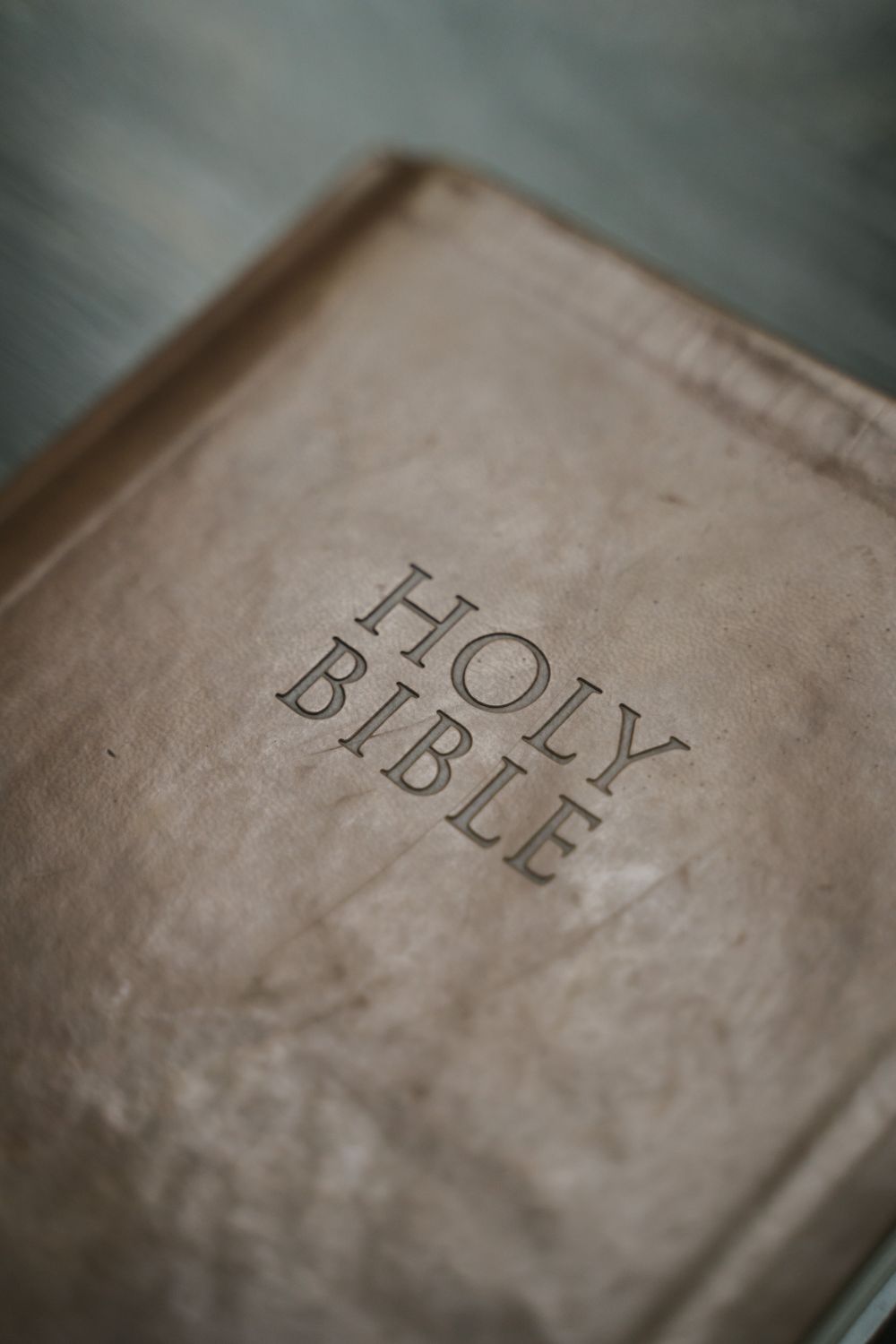 Detailed close-up shot of an antique Holy Bible cover, highlighting texture and design.