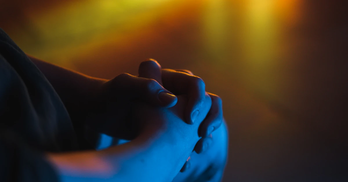 a close up of a person holding their hands together